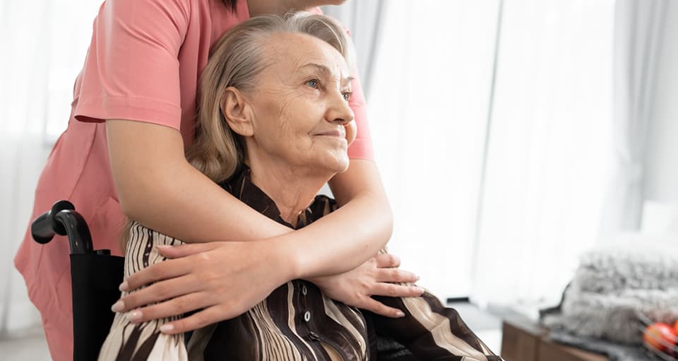 Nurse comforting patient in wheelchair