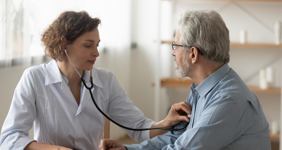 Doctor using stethoscope on patient